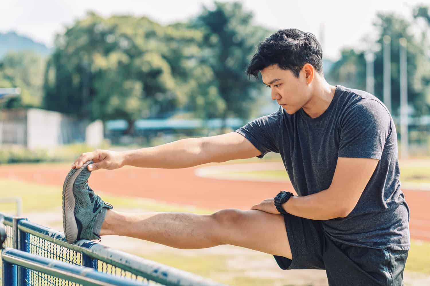 A young man stretching for track.