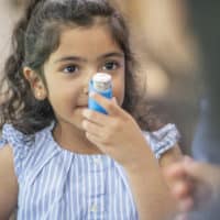 Small girl and her inhaler.