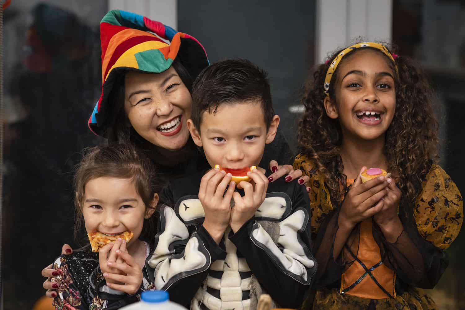 Children in Halloween costumes eating candy.